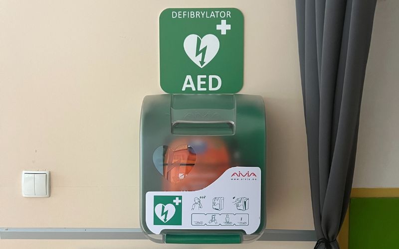 Zdjęcie przedstawia zamontowany defibrylator AED na ścianie