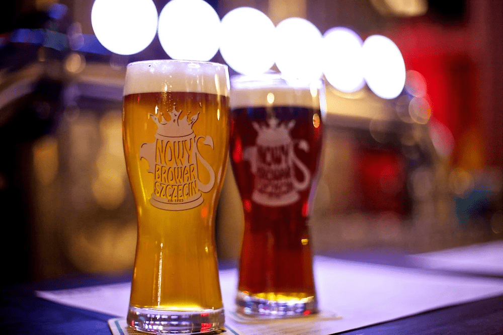 obraz przedstawia dwie szklanki do piwa z jasnym i ciemnym piwem. na szkle widnieje logo Nowego Browaru w Szczecienie