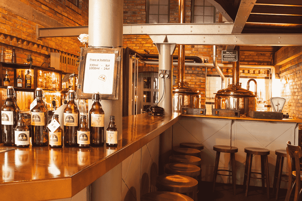 obrazek przedstawia wnętrze Starego Browaru w Szczecinie- wysokie krzesła i ladę