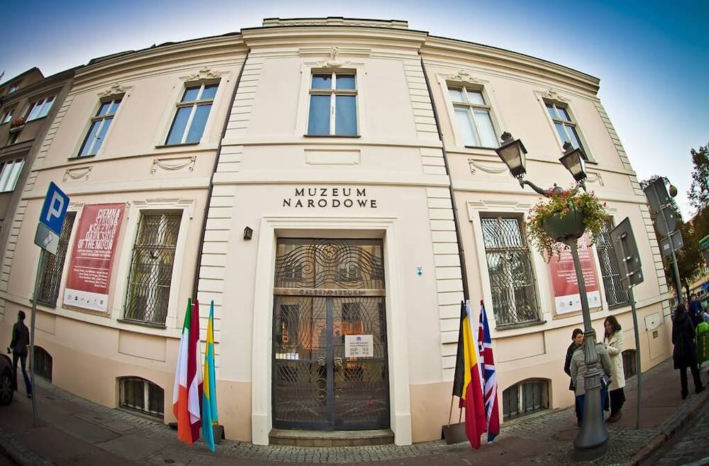 obraz przedstawia przednie wejście Muzeum Sztuki Współczesnej w Szczecinie; zdjęcie zostało obiektywem typu "fish-eye"