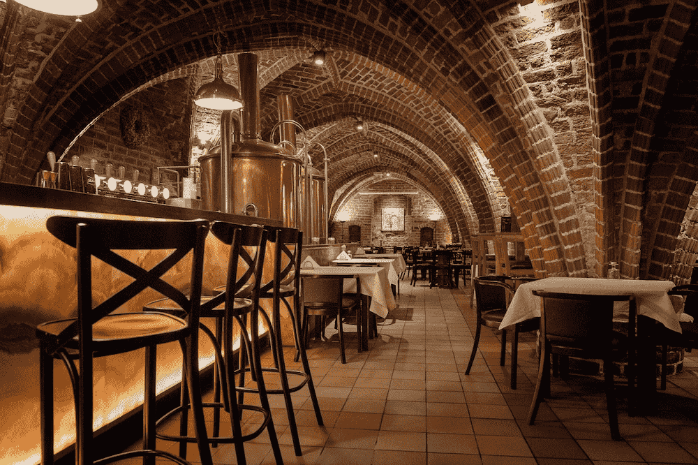 obraz przedstawia wnętrze Browaru Rodzinnego Wyszak ze Szczecina. Widoczne są piękne ceglane sklepienia.