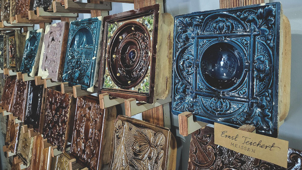 obraz przedstawia wystawę pojedynczych, kolorowych kafelków; przestawiają one m.in widoki i symetryczne wzory