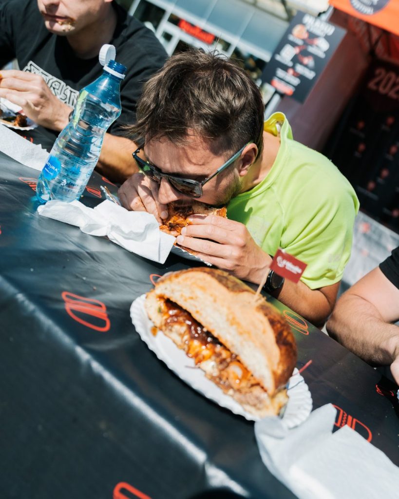 Osoba jedząca burgera na festiwalu w Szczecinie