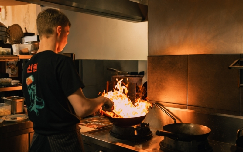 Kucharz przygotowujący danie w tajskiej restauracji Kinnari w Szczecinie