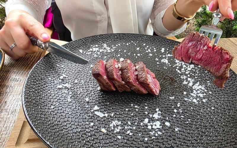 Pokrojony stek Wagyu podany na czarnym talerzu
