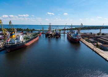 Widok z lotu ptaka na teren stoczniowy w Szczecinie z dokami, statkami i infrastrukturą portową
