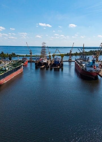 Widok z lotu ptaka na teren stoczniowy w Szczecinie z dokami, statkami i infrastrukturą portową