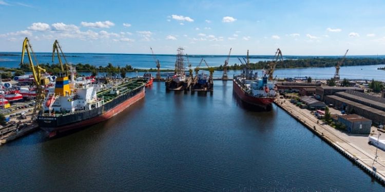 Widok z lotu ptaka na teren stoczniowy w Szczecinie z dokami, statkami i infrastrukturą portową