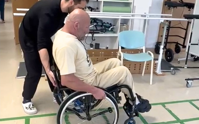 Zdjęcie przedstawia Macieja Światłowskiego na wózku podczas rehabilitacji