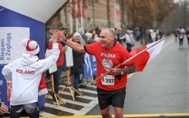 Biegacz z polską flagą podczas wcześniejszego Biegu Niepodległości