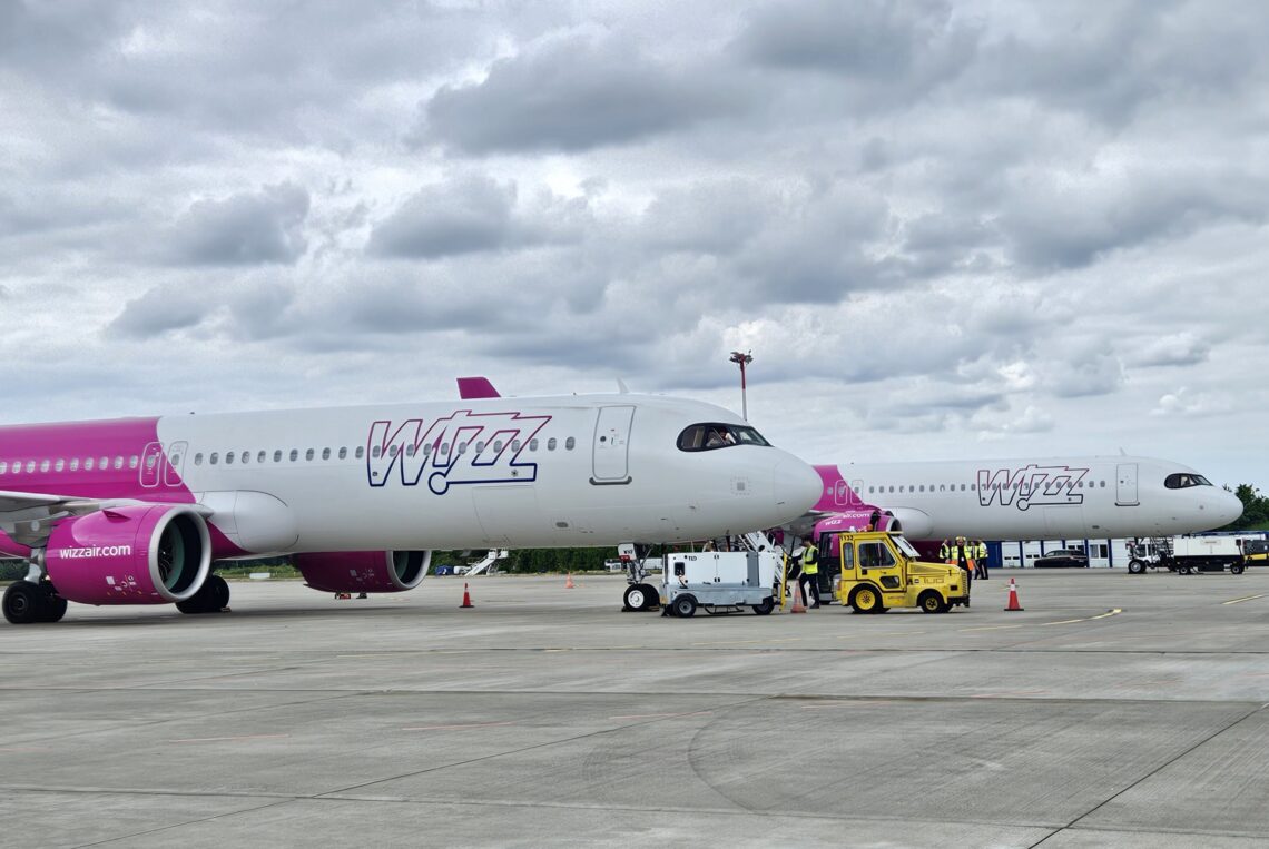 Dwa samoloty Wizz Air i pojazdy obsługi na lotnisku Szczecin-Goleniów
